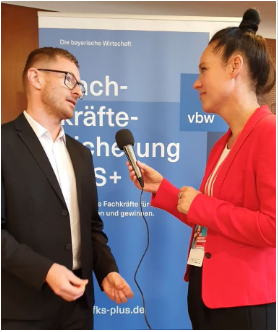 Eine Frau interviewt einen Mann auf der Messe.
