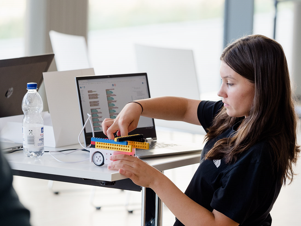 Eine Schülerin baut aus mit Lego einen selbst fahrenden Roboter.
