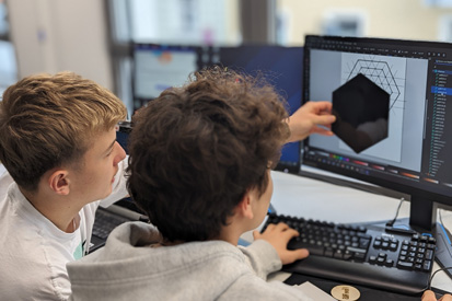 Zwei Jungen programmieren am Computer.