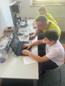 Drei Jungs programmieren gemeinsam.