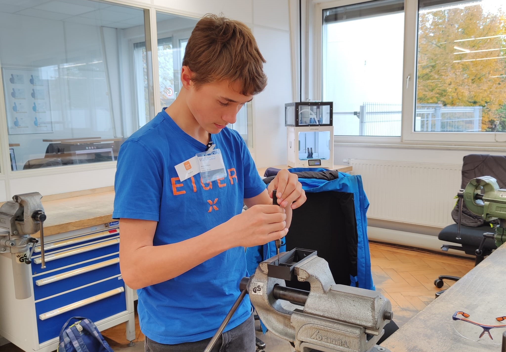Ein Schüler schraubt an einer Werkbank.