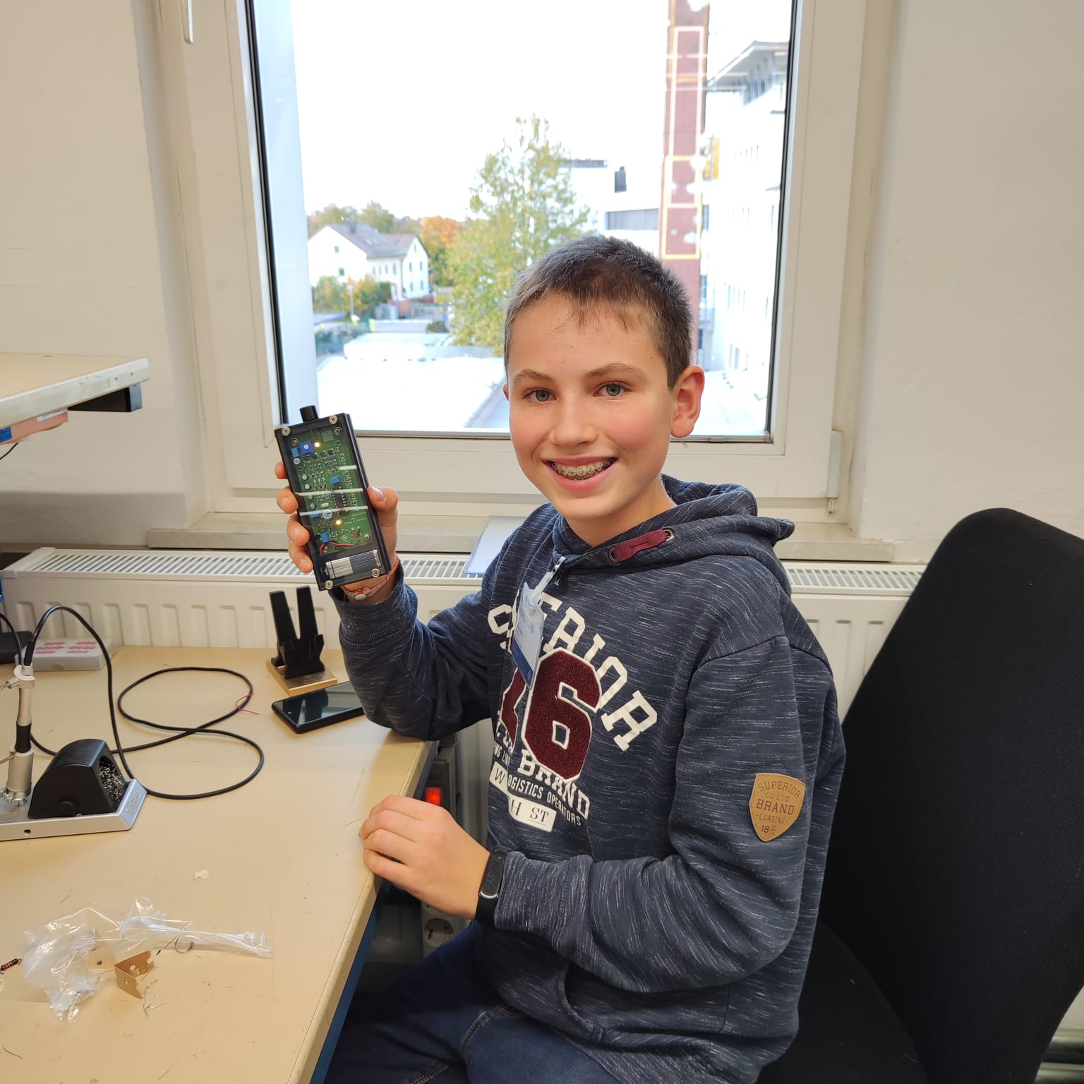 Ein Schüler präsentiert sein selbstgebautes Schaltbrett.