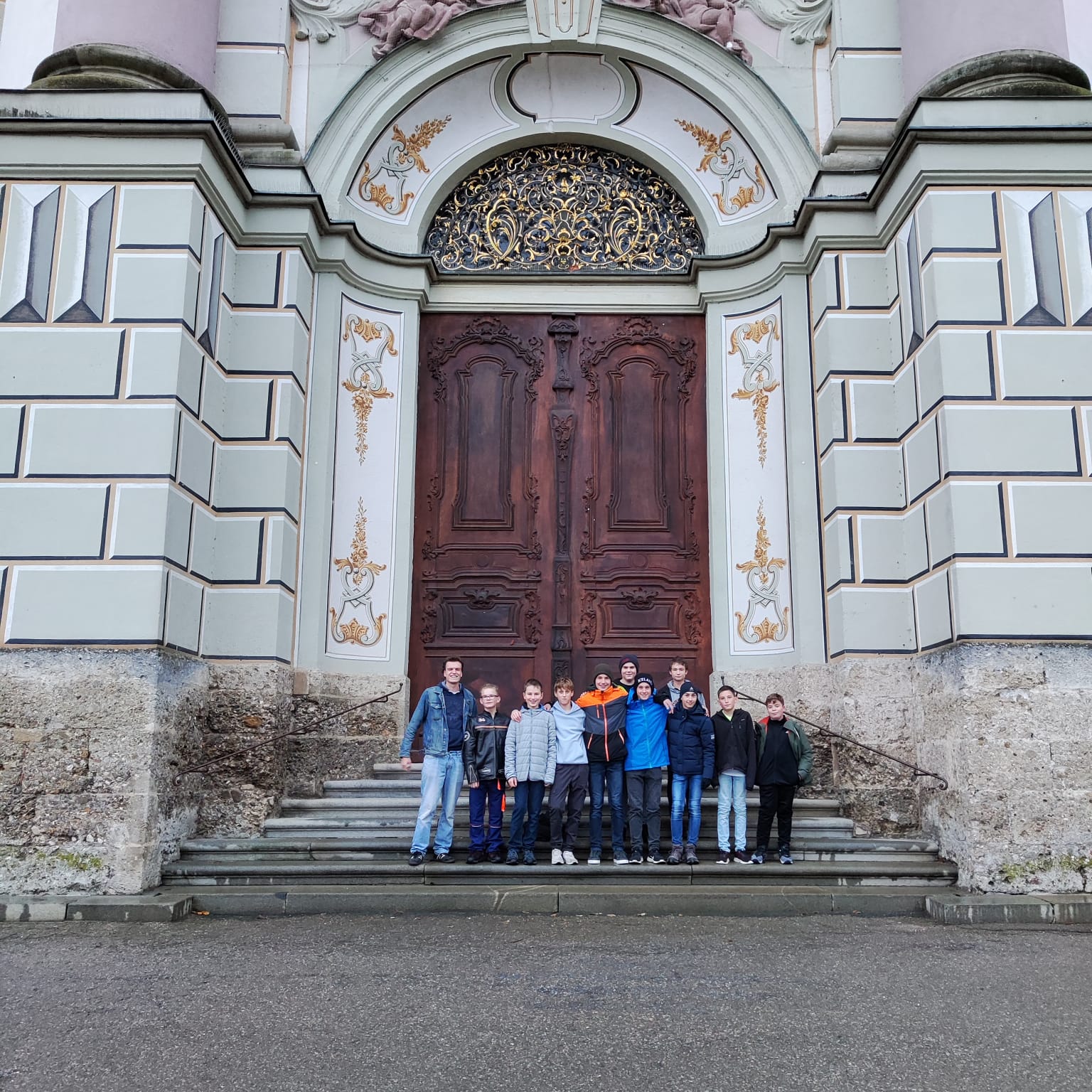 Eine Gruppe Schüler vor dem imposanten Eingang einer Kirche.