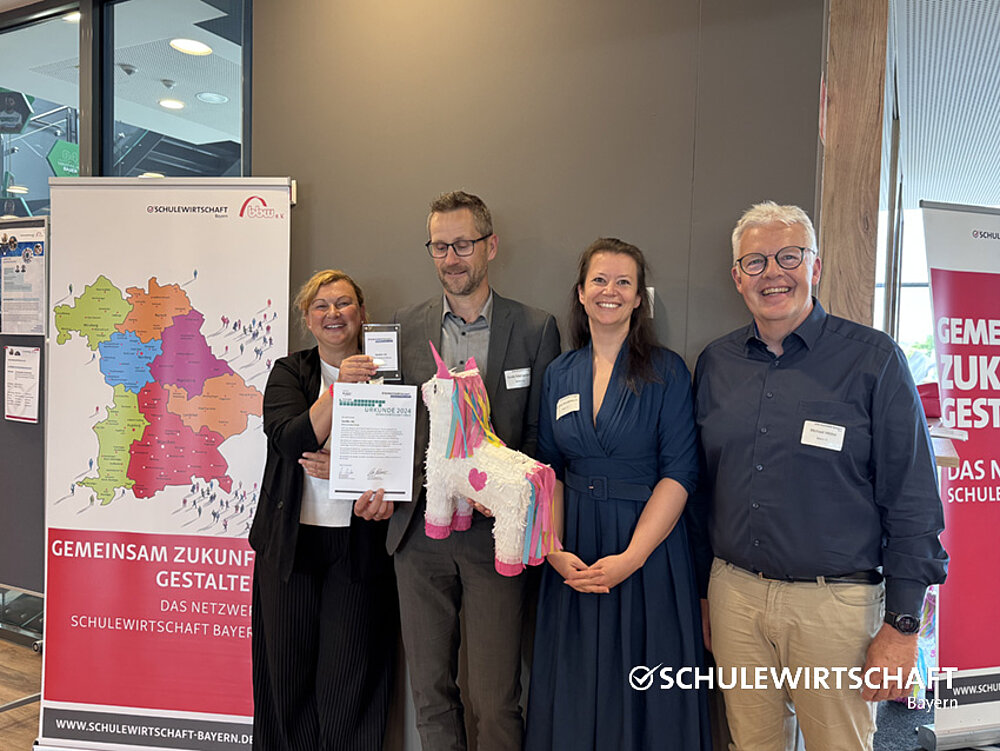 Die Gewinnerinnen und Gewinner präsentieren die Urkunden und eine Piñata.