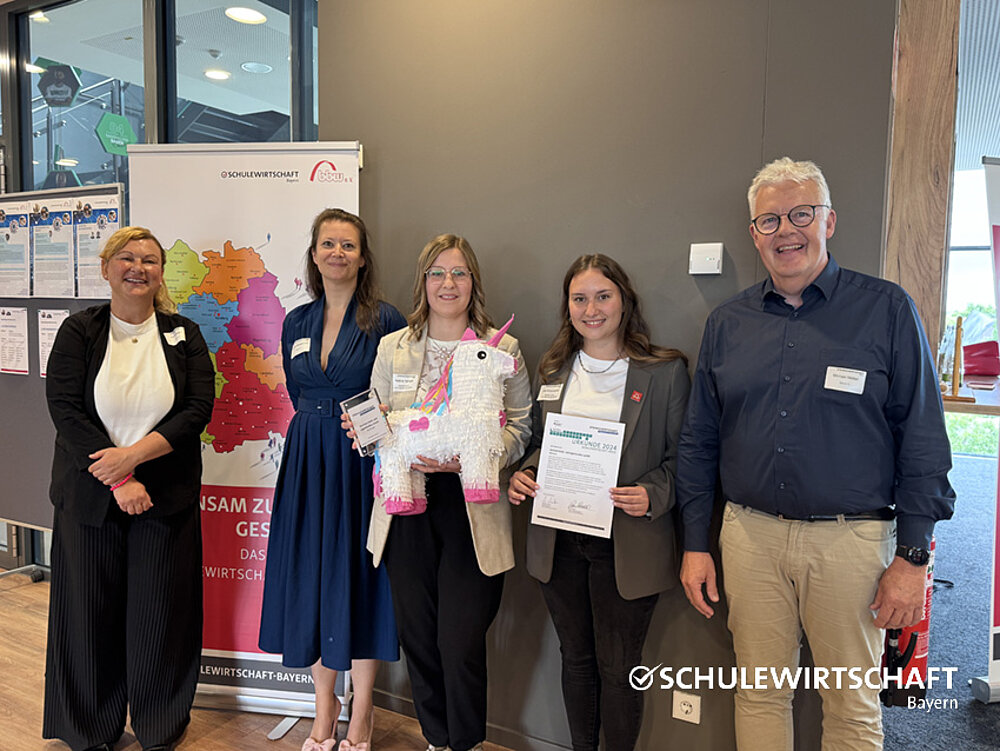 Die Gewinnerinnen präsentieren die Urkunden und eine Piñata.